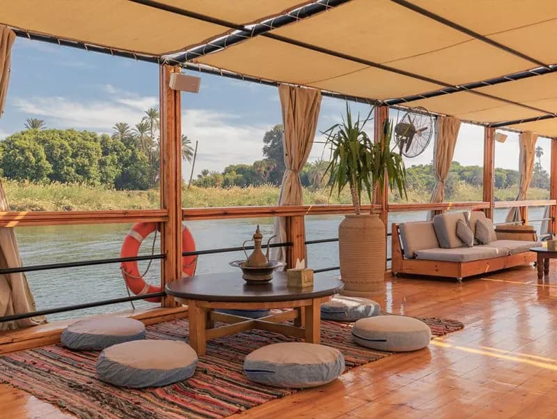 Entspannen im schattigen Loungebereich am Wasser Offener Lounge-Bereich der Nuun Dahabiya mit Sitzkissen und Nilblick